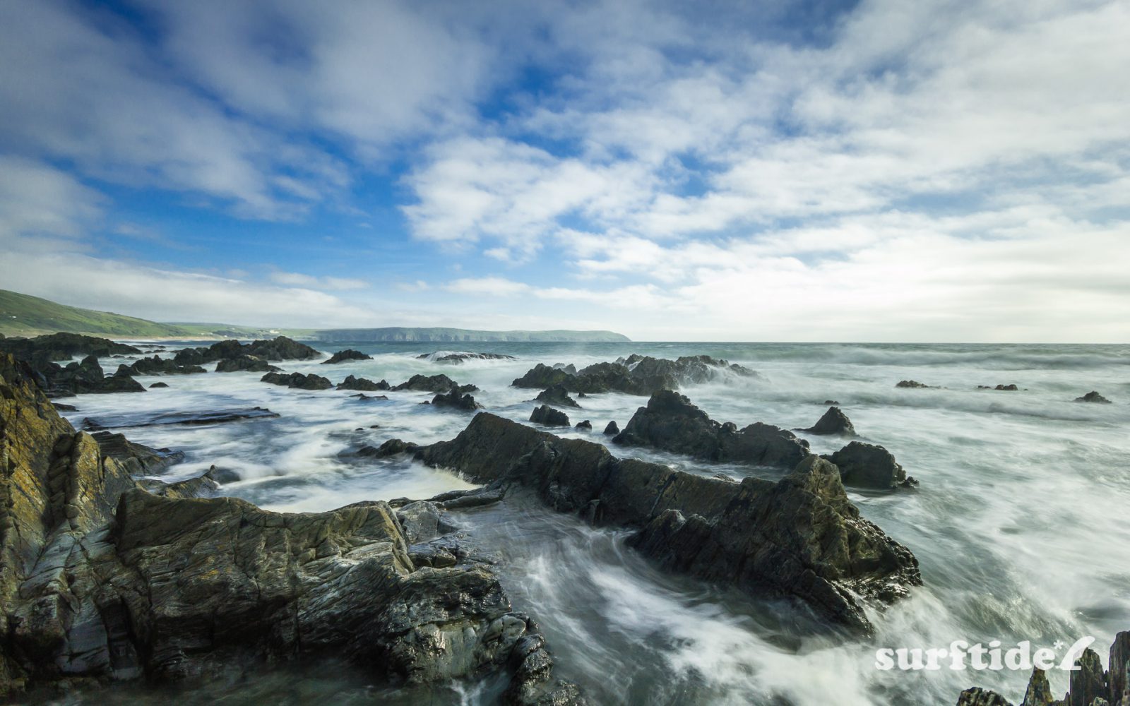Long exposure photo of the waves breaking on the rocks next to Barricane Beach in North Devon, England