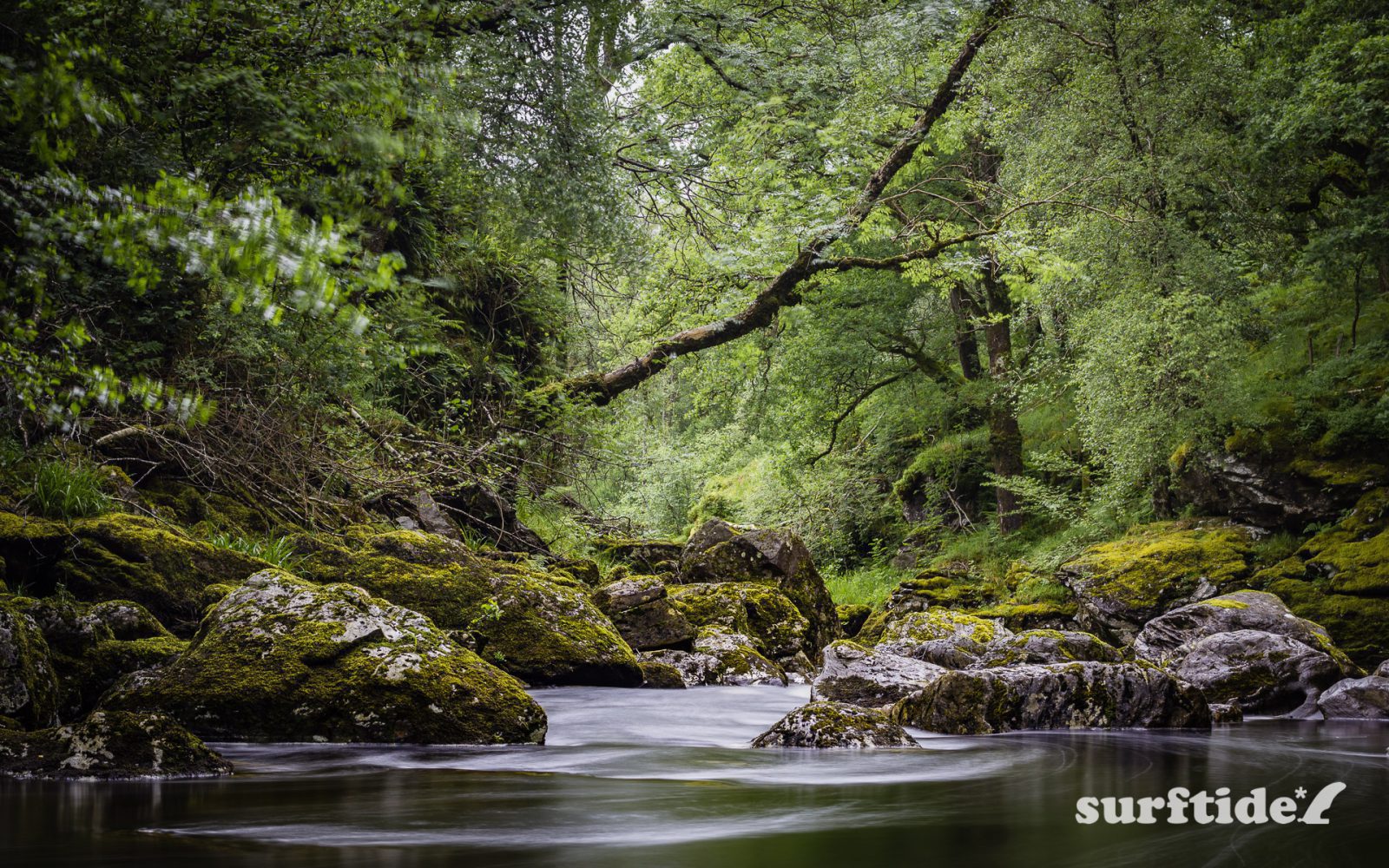 Long exposure photo showing flowing water in the rock pools at The Falls of Falloch in Stirling, Scotland