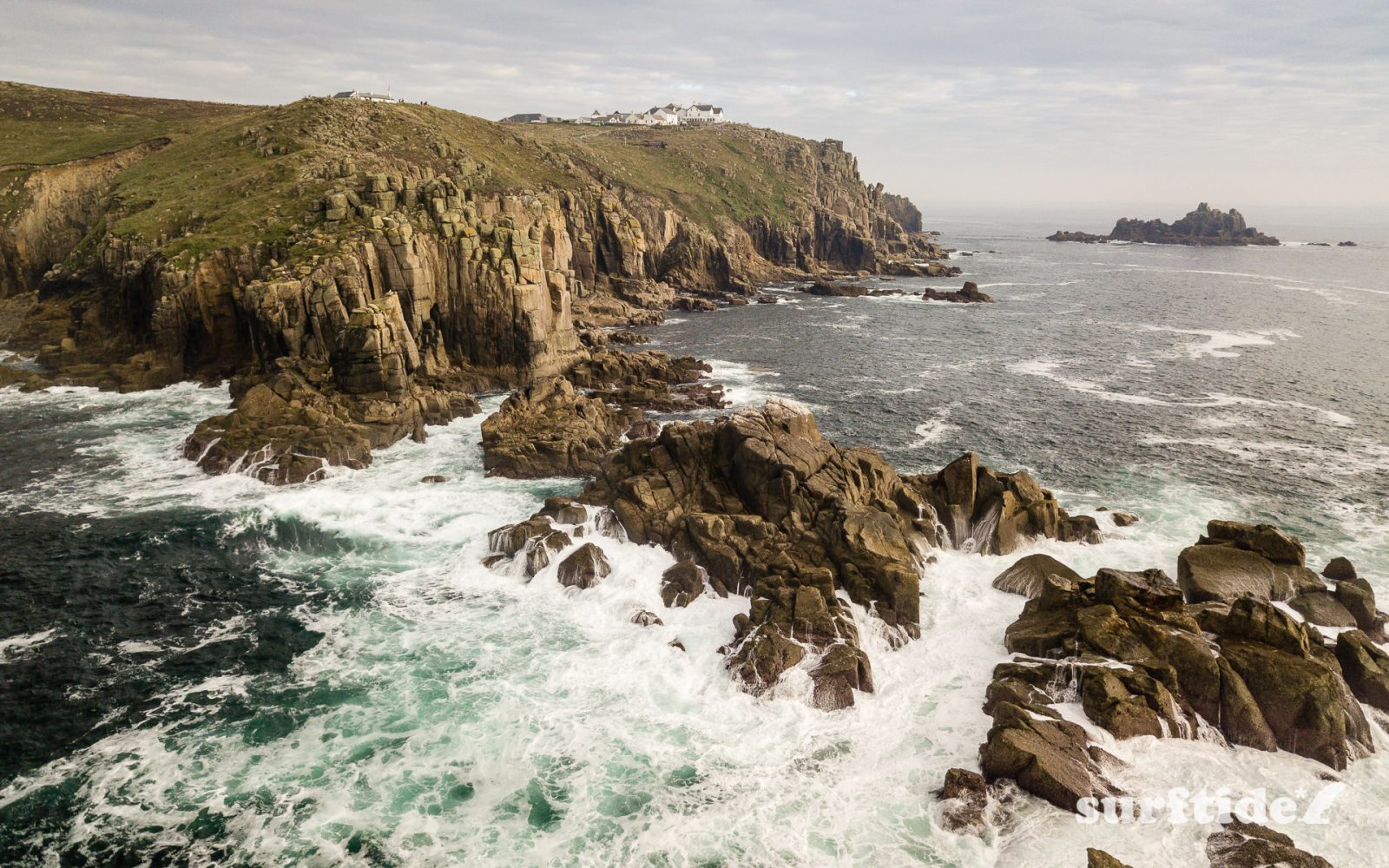 Aerial photo of the waves crashing in on the rocks at Land's End, Cornwall, England