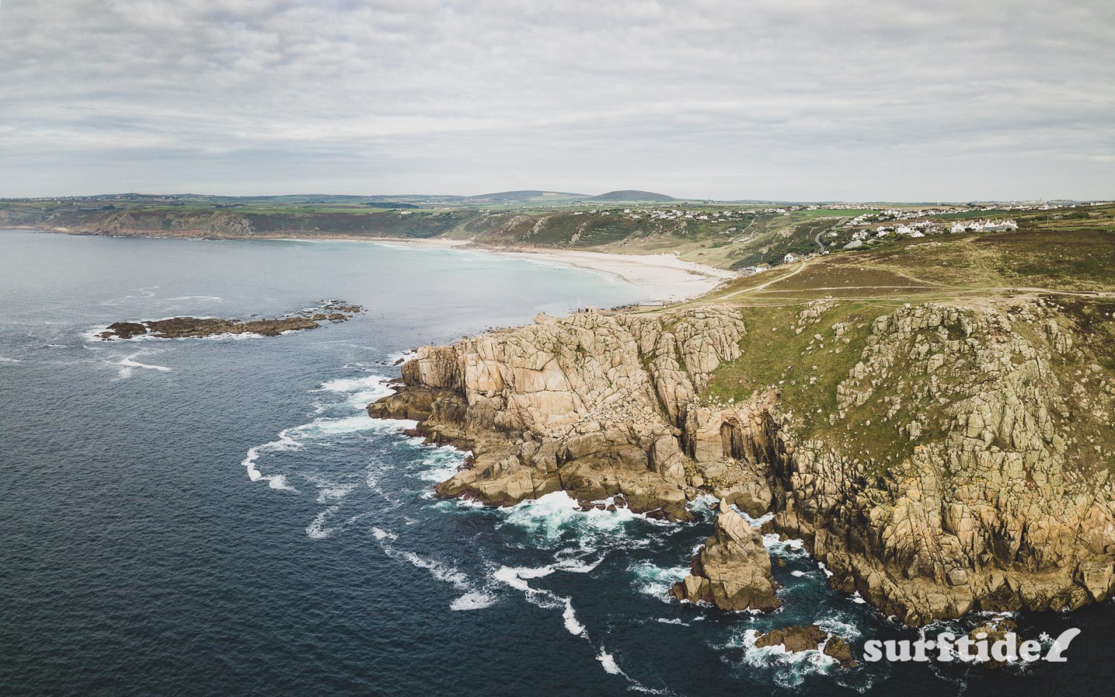 Aerial photo of the sea and rocky cliffs near Sennen Cove, Cornwall, England