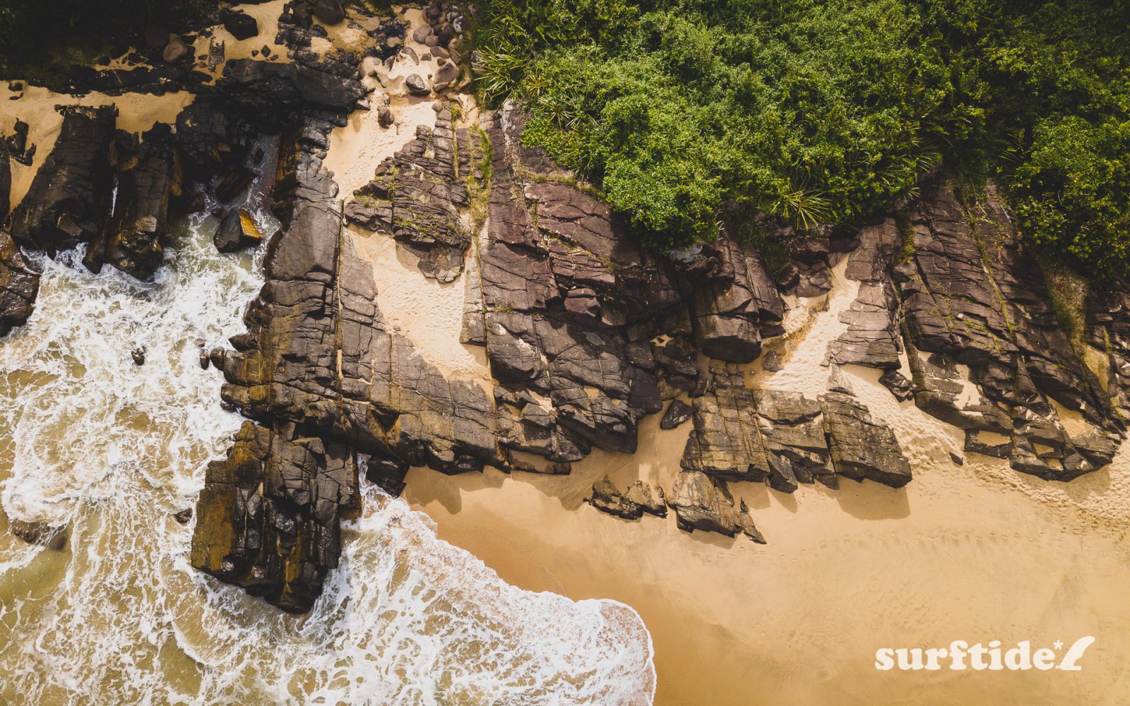 An aerial photo of the beautiful rock strata and sandy beach